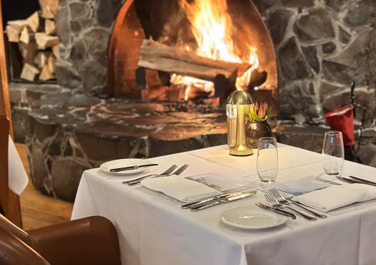 dining table with setting next to fireplace