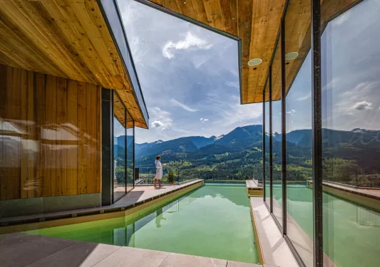 Woman standing in a robe at an oudoor pool