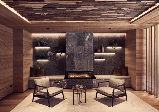 Indoor seating area with two cushioned chairs and a stone fireplace in the background