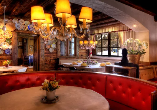 large red booth around a table under a chandelier