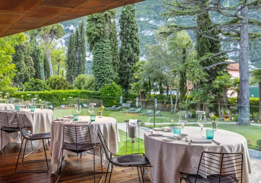 Multiple dining tables on the balcony overlooking a large grass area