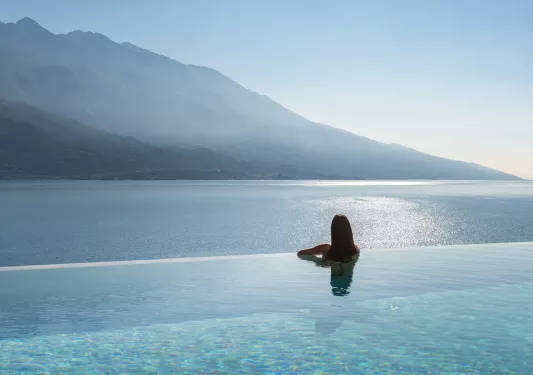 woman in infinity pool looking over the water 