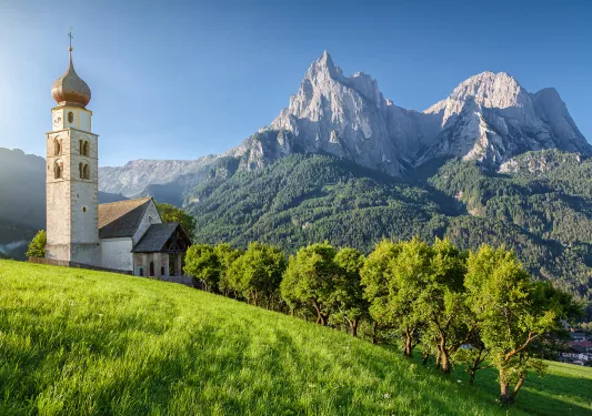 Rustic church next to a tall mountain in the background