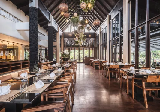 Indoor dining hall with wooden chairs and large windows on the walls