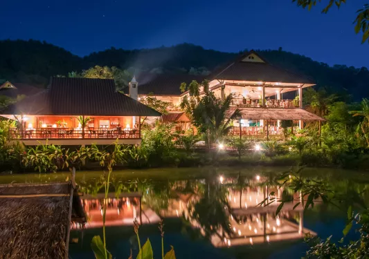 Outdoor bungalows illuminated by lights in the evening