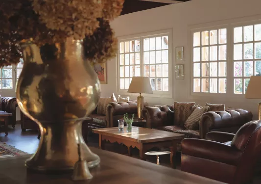 Indoor lounge with copper vases and brown cushioned sofas