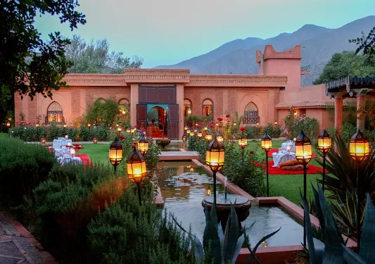 Outdoor garden in front of a stone building and a small pond