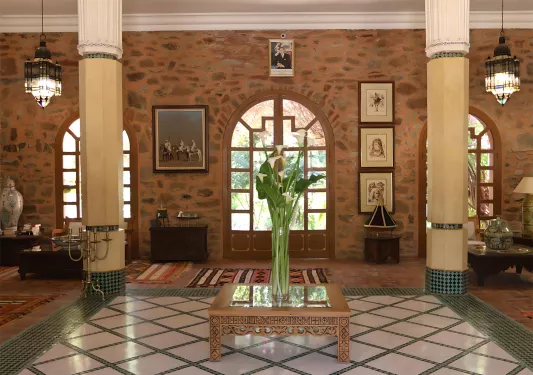 Indoor lobby with a vase full of plants in the center and two large pillars on either side