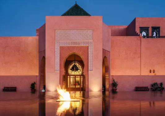Large stone building with an infinity fountain and a firepit in front