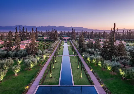 Sky view of long fountain with concrete pathways on either side