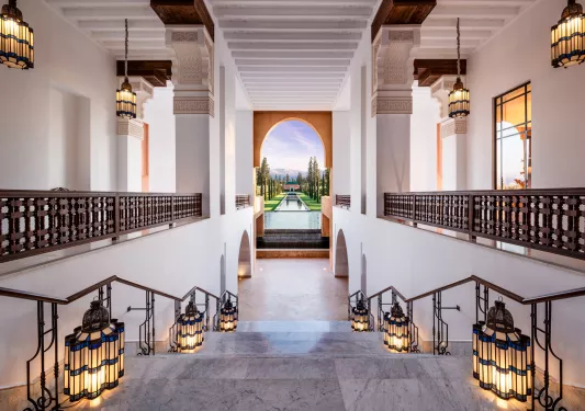 Indoor staircase with marble floors and chandeliers