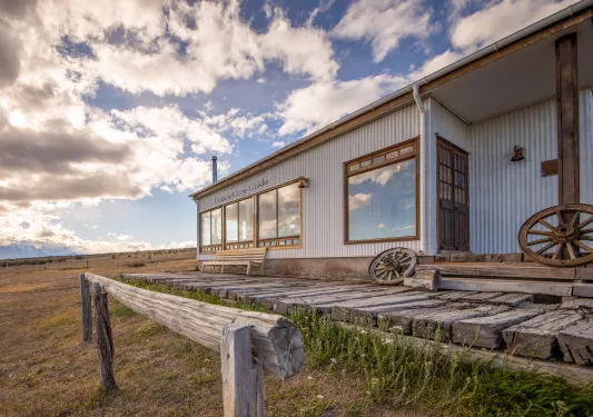 Metal building with a wooden porch and wooden wheels in front