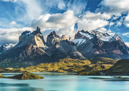Lake with snow-capped mountains and clouds in the distance