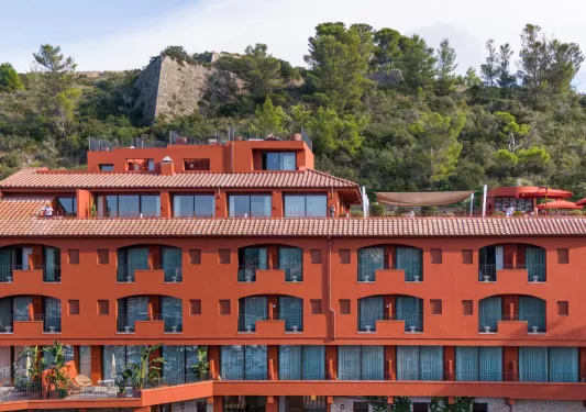 Red hotel building with individual balconies per room