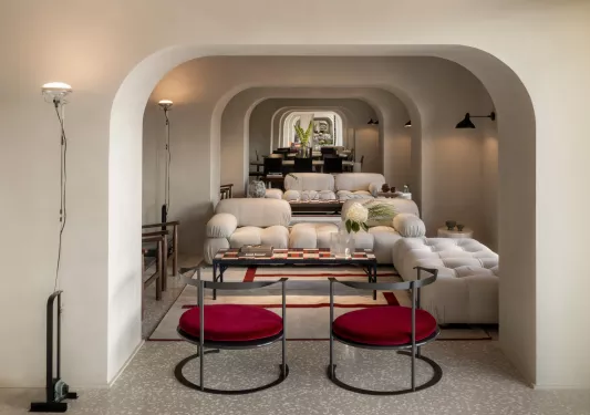 Lounge with arched hallways with white and red cushioned seating
