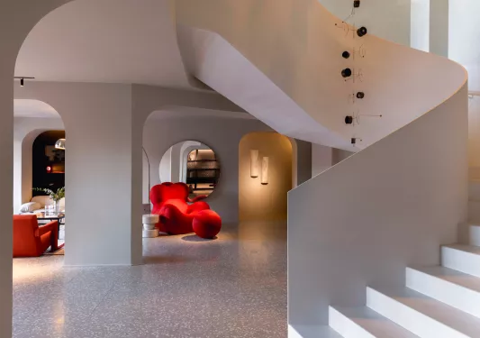 Lobby with red, cushioned chairs and a white staircase