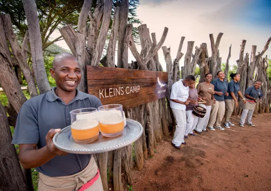 Hotel staff greeting guests at entrance sign