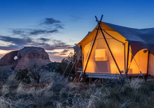 Glamping tent lit up in the desert