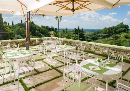 large terrace with bistro tables and umbrellas covering them