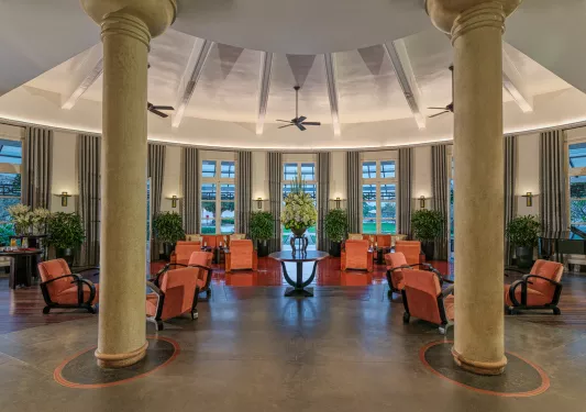 Hotel lobby with stone flooring and two large, stone pillars