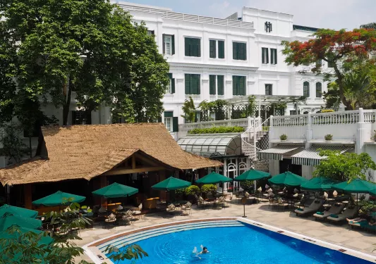 outdoor swimming pool surrounded by green umbrellas