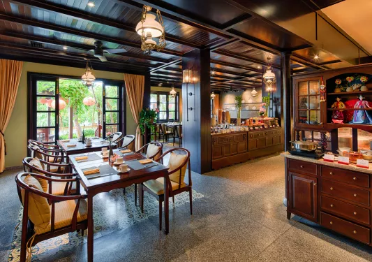 Dining area with tables to the left and buffet-style trays on the right