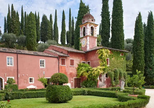 Rustic, red building with a clocktower attached to it