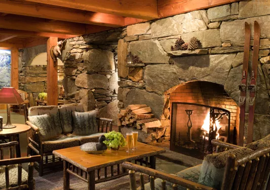 Stone fire place with wood furniture and chairs in front