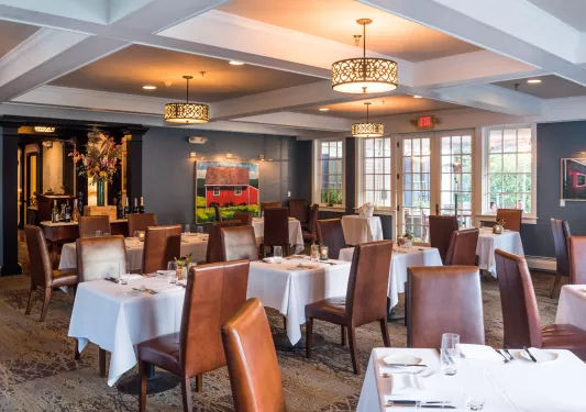 Indoor dining hall with brown, leather chairs and white tables