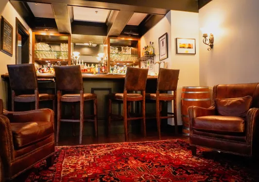 Indoor bar with leather stools and brown leather lounge chairs