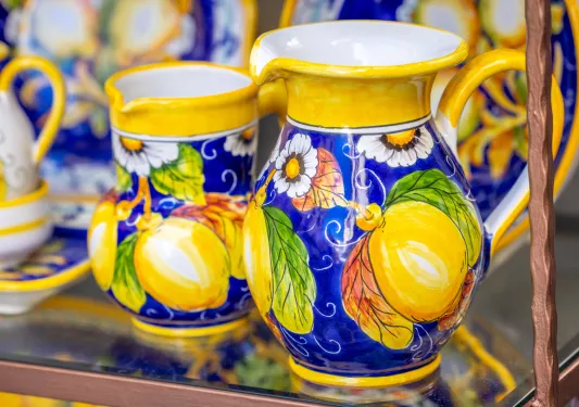 Two mugs, painted with yellow lemons on a blue background