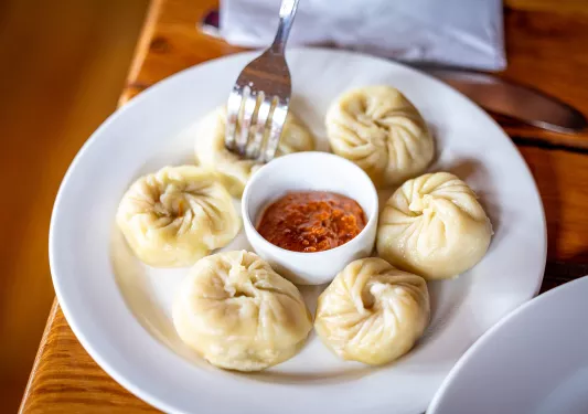 Plate of dumplings with a chili sauce in the center of the plate