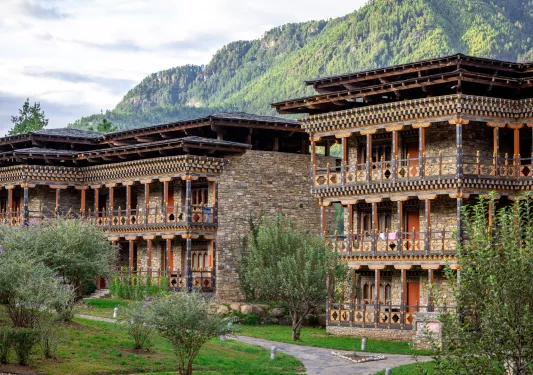 Outdoor view of three-story brick building with a grass courtyard in front