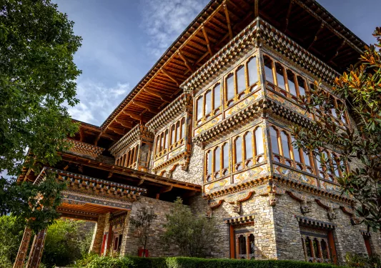 Outdoor view of three-story hotel building with stone walls