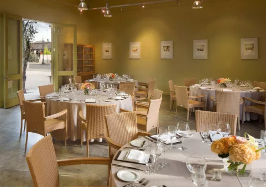 Dining room with tabls and glasses on wine with the door open on the left