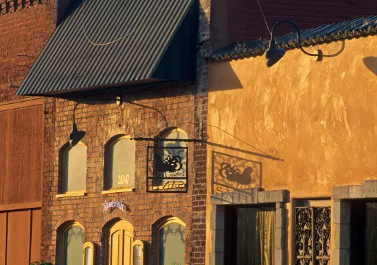 Brick buildings with plants and benches outside during sunset