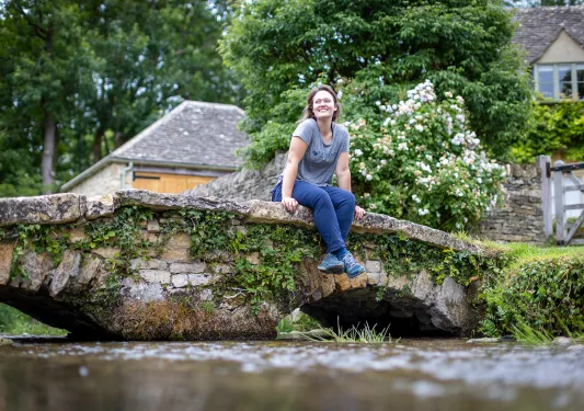 Woman sitting on a stone bridge looking to the left