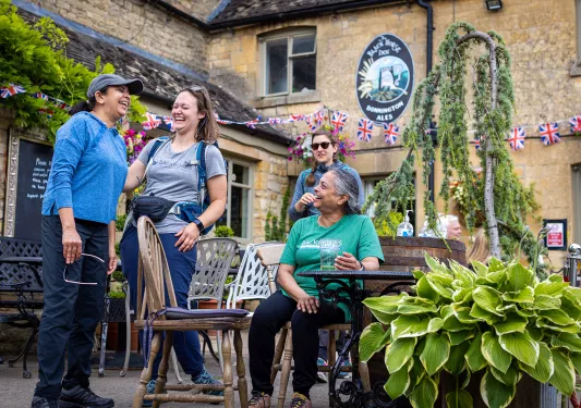 Four women laughing and smiling in an outdoor patio