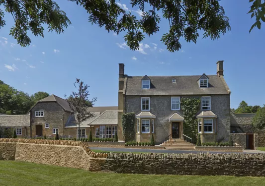 large stone house surrounded by low stone wall