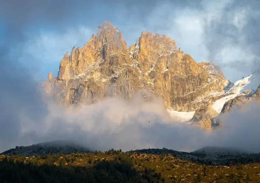 Large, jagged mountain covered in fog, with a large valley on the ground floor