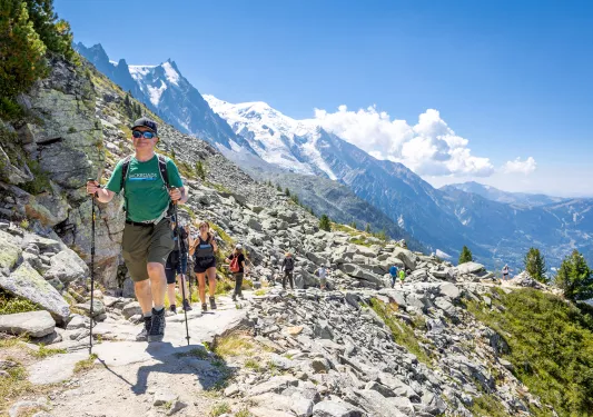 Group of people walking on a stone and gravel trail on a moutanin