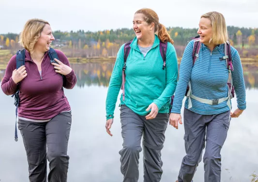 Three women smiling while hiking