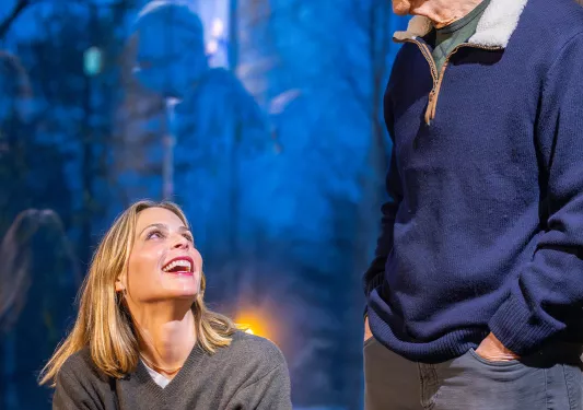 Woman looking up towards a man in a wooden style lodge