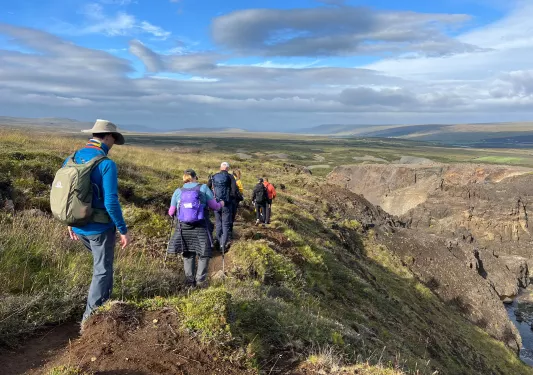 Hikers walk along a rocky mountain path