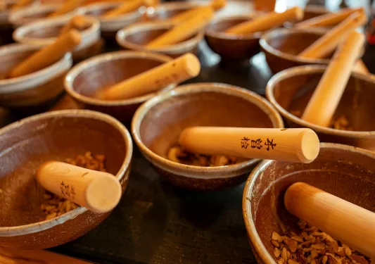 Multiple mortar and pestles on a wooden table