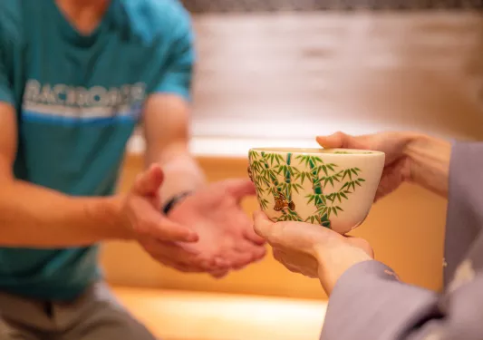 a person hands a bowl to a backroads guest