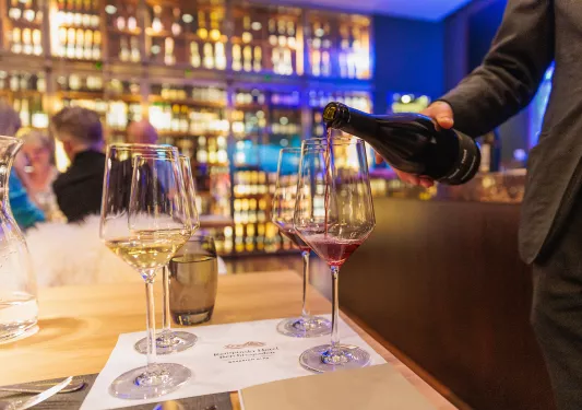a server pours wine into glasses