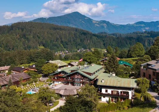 Exterior, sky view of wooden hotel building complex in a valley of tall trees