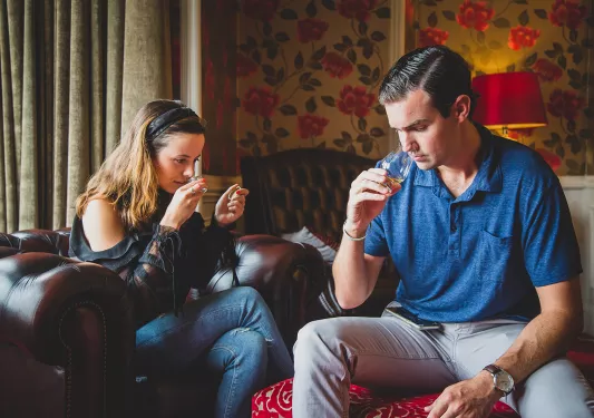 Man and woman smelling glasses filled with liquor