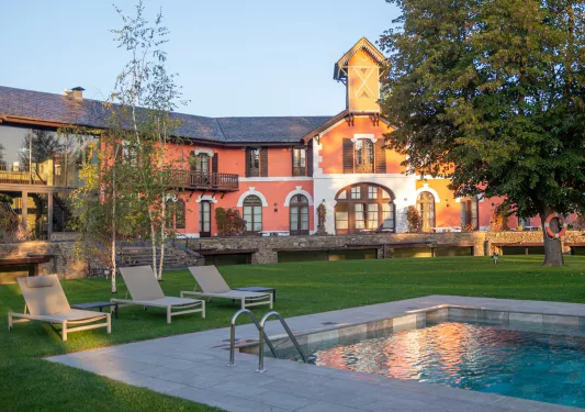Outdoor pool with a building in the background with balconies